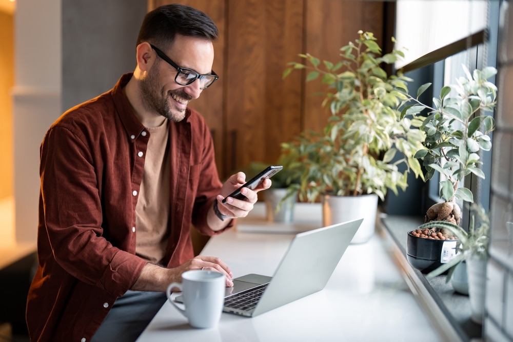 Man sitting at a table and glancing at his phone.