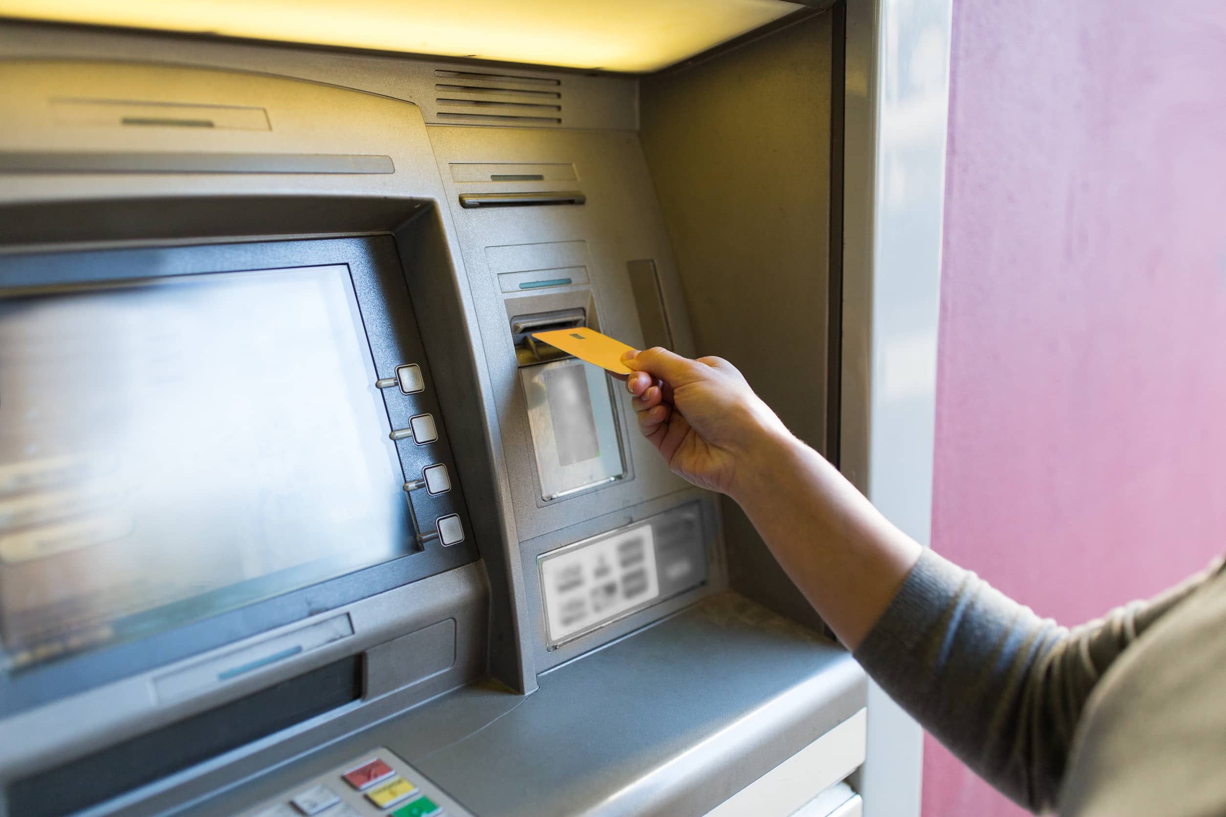 close up of woman inserting card to atm
