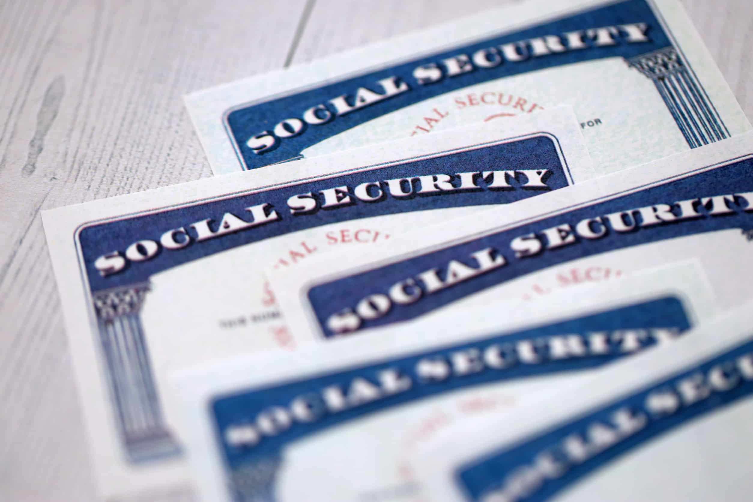 Social security number cards on white wooden background surface close up