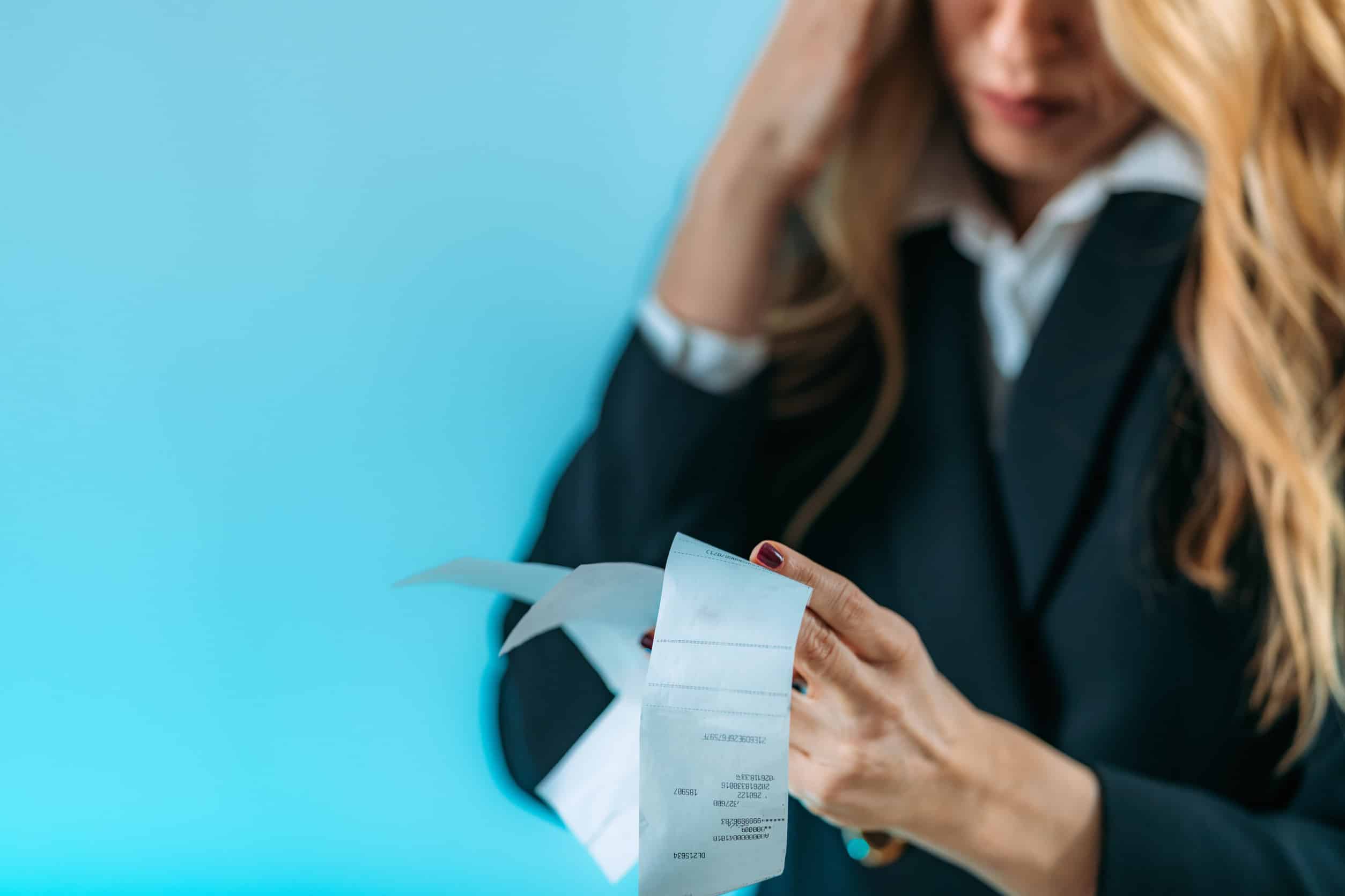 Worried business woman holding bills