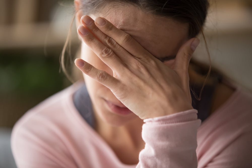 Sad woman leaning into her hand.