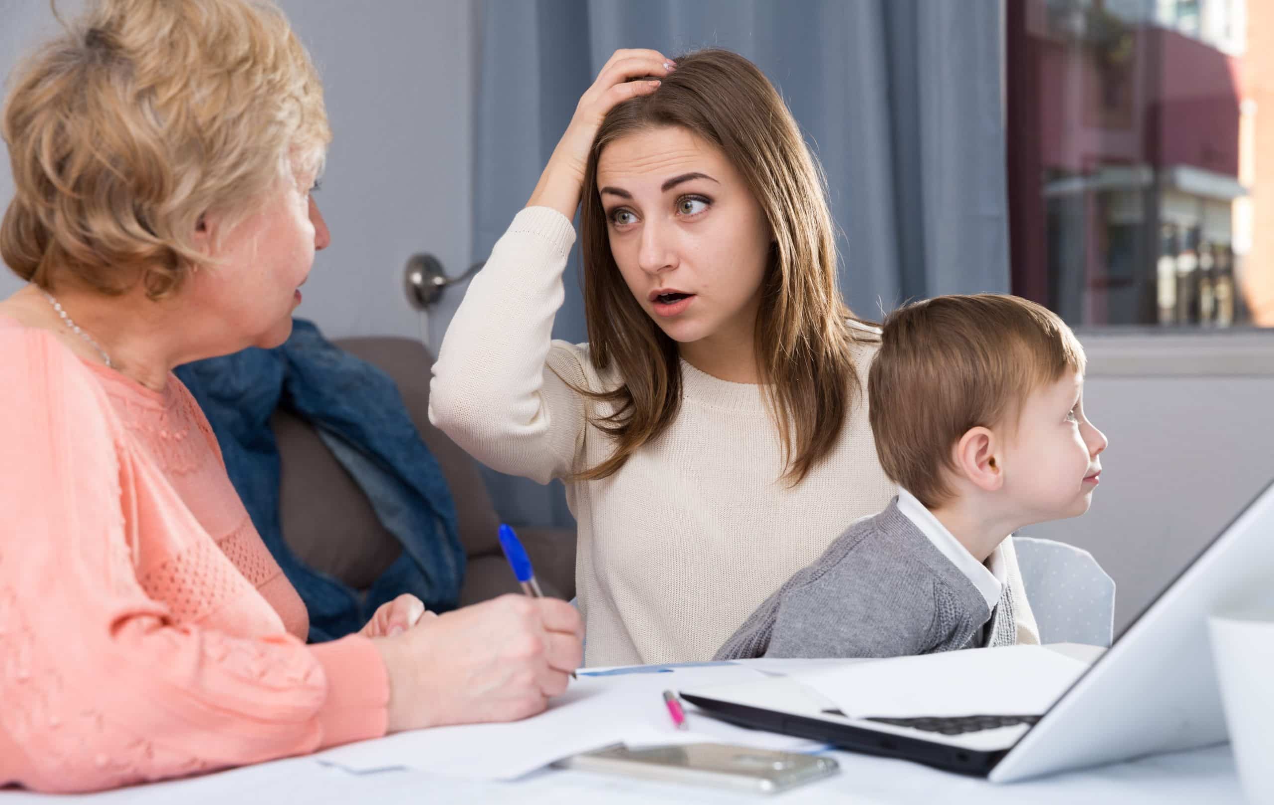 Mother and grandmother looking concerned with child in front of computer